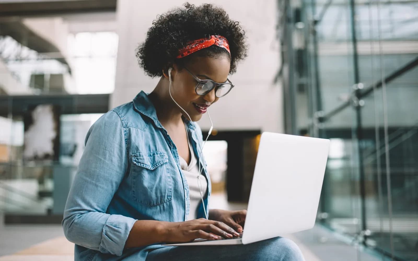 An adult studying on a laptop with headphones